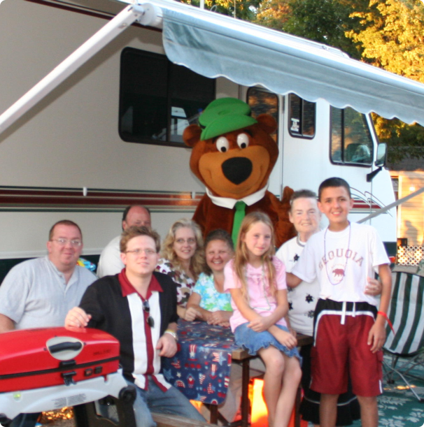 A diverse family of four, smiling together in a park, showcasing love and togetherness