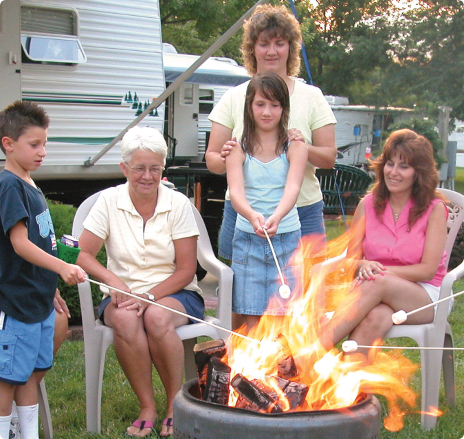 Family sitting outside roasting marshmallows over a fire
