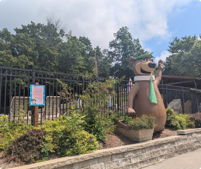 A bear statue wearing a green hat and a green tie