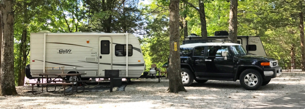 A black truck parked beside a recreational vehicle (RV)