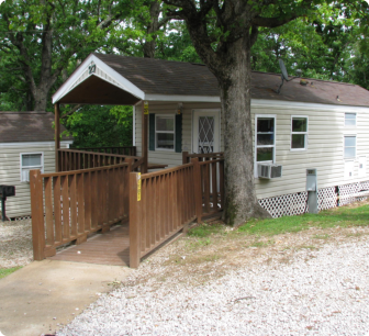A small house featuring a porch and surrounded by a wooden fence