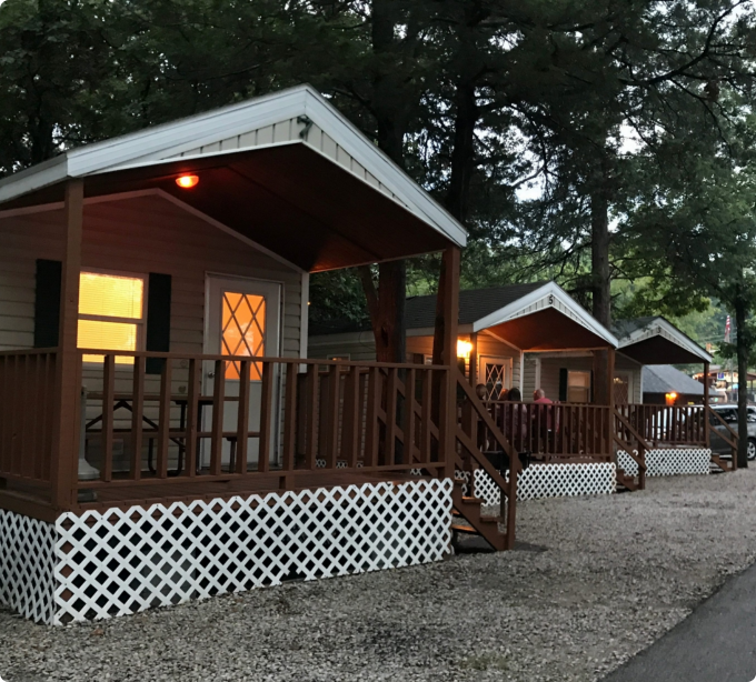 A row of small cabins featuring porches with lights