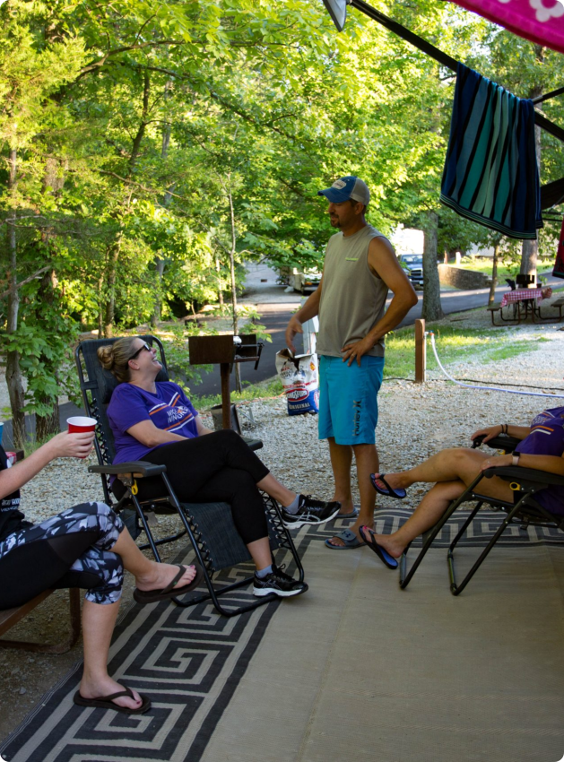 A group of diverse people sitting together on a sunny patio, enjoying conversation and drinks.
