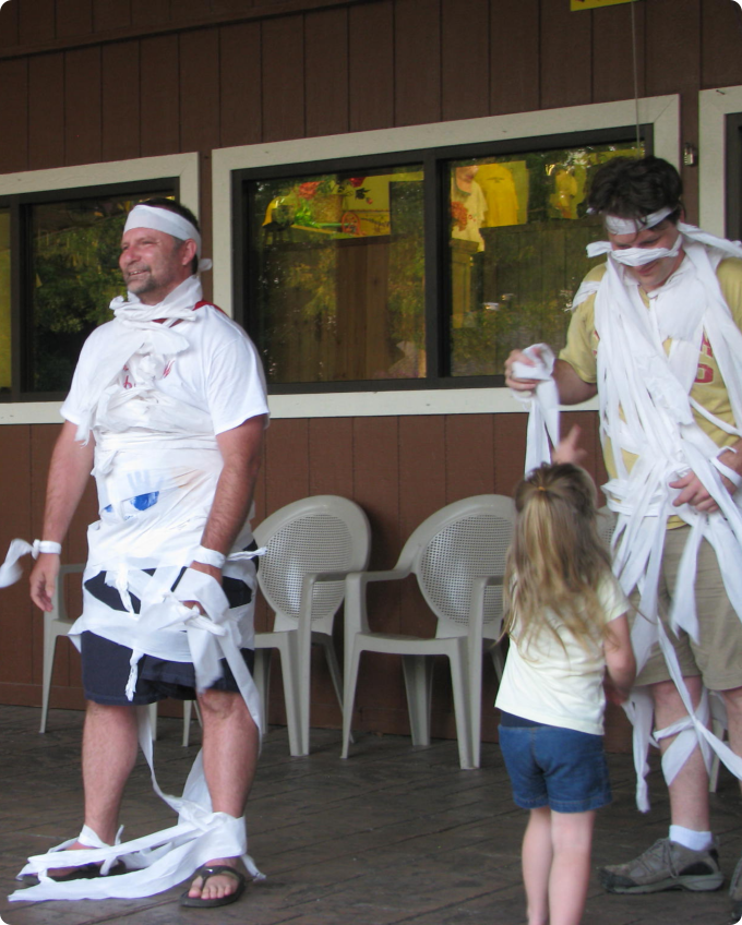 A man and a child joyfully play with a roll of toilet paper