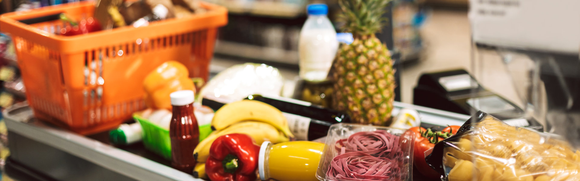 A grocery store aisle featuring a shopping cart filled with various food items