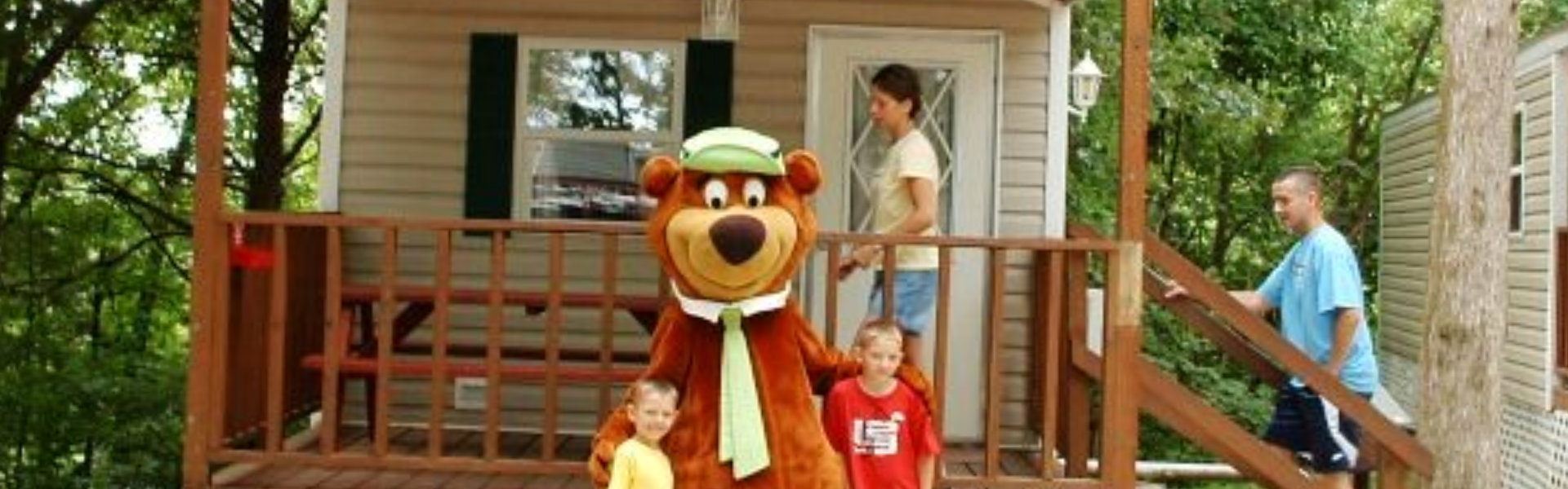 A family stands together on the porch of a cozy cabin